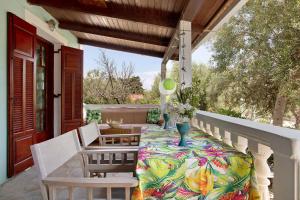 a porch with a table and chairs on a balcony at Areti Orfeas Apartment 6 in Vasilikos