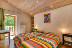 a bedroom with a bed with a colorful striped blanket at Maison Citron in Aspiran +26 photos