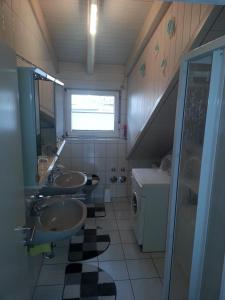 a bathroom with three sinks and a window at Fewo Singler in Hofstetten