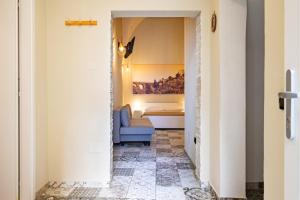a hallway with a blue couch and a bed at Sg Apartment Standard Plus in Massafra
