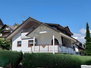 a white house with a porch and a balcony at Fewo Singler in Hofstetten +9 photos