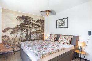 ein Schlafzimmer mit einem Bett und einem Gemälde an der Wand in der Unterkunft Casa-Sarah Ferienwohnungen in Homberg
