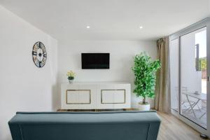 a living room with a couch and a tv on a wall at Studio Casa Belavista in Gaula