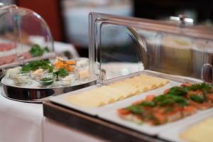a buffet with cheese and other food on a table at Hotel König von Ungarn in Vienna