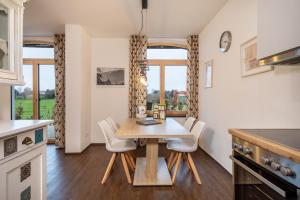 a kitchen and dining room with a wooden table and chairs at Butterei in Argenbühl