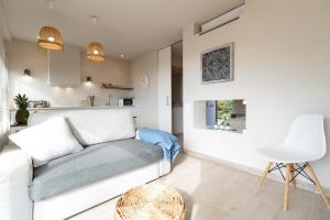 a living room with a white couch and a table at Ocean view apartment renovated in Gavà