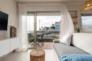 a living room with a couch and a large window at Ocean view apartment renovated in Gavà