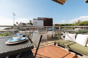 a patio with a table and chairs on a balcony at Ocean view apartment renovated in Gavà