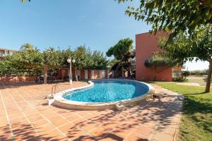 a swimming pool in a yard next to a house at Ocean view apartment renovated in Gavà