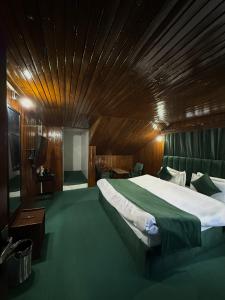 a bedroom with a large bed with a wooden ceiling at Riverdale by Stay Pattern in Pahalgām