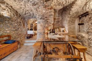 a room with a stone wall and a table with a machine at Logge dei Paroloti Agnese in San Lorenzo in Banale
