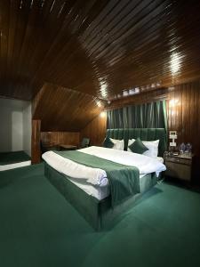a bedroom with a large bed with a wooden ceiling at Riverdale by Stay Pattern in Pahalgām +8 photos
