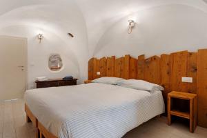 a bedroom with a large bed with a wooden headboard at Logge dei Paroloti Agnese in San Lorenzo in Banale
