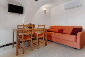 a living room with a couch and a table and chairs at Logge dei Paroloti Agnese in San Lorenzo in Banale