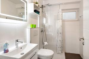 a white bathroom with a toilet and a sink at Agricola in Bad Säckingen +15 photos