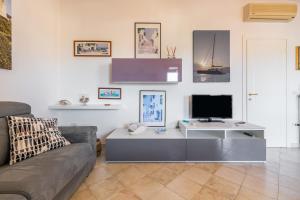 a living room with a couch and a television at Attico il Mandorleto in Villasimius