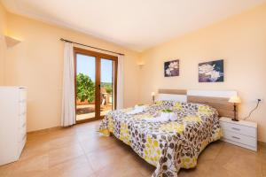 a bedroom with a bed and a sliding glass door at Sa Xorca in Santanyi +20 photos