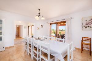 a white dining room with a white table and chairs at Sa Xorca in Santanyi