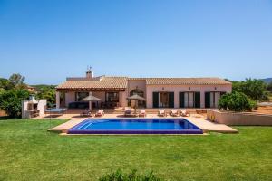 a house with a swimming pool in a yard at Sa Xorca in Santanyi