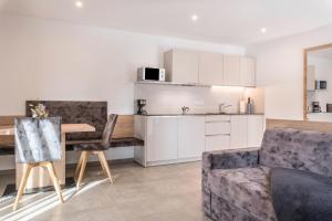 a kitchen and living room with a table and a couch at Aster Moments Apt Max in San Genesio Atesino