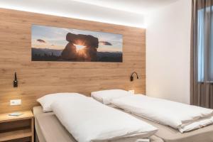 a bedroom with two beds and a painting on the wall at Aster Moments Apt Max in San Genesio Atesino