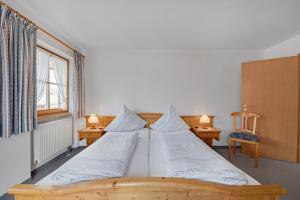 a bedroom with a bed with two tables and two lamps at Petrushof Ferienwohnung Taubensee in Oberwössen