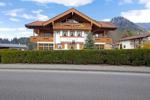 a large wooden house on the side of a street at Petrushof Ferienwohnung Taubensee in Oberwössen