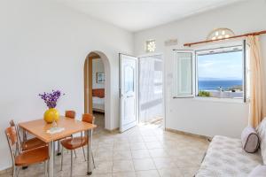 a living room with a table and a view of the ocean at Anemologio 304 Tinos in Agios Ioannis