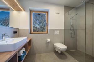 a bathroom with a sink and a toilet and a window at sunnig Apartment Morgensonne in Vollan +12 photos