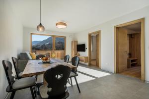 a dining room and living room with a table and chairs at sunnig Apartment Morgensonne in Vollan