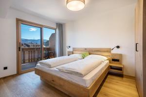 a bedroom with a bed and a balcony at sunnig Apartment Morgensonne in Vollan