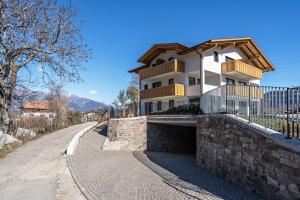 a house on a stone wall next to a street at sunnig Apartment Morgensonne in Vollan