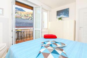 a bedroom with a blue bed and a balcony at Liver 201 in Tremosine Sul Garda