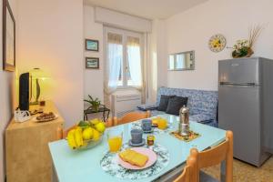 a kitchen and living room with a blue table with fruit on it at Liver 201 in Tremosine Sul Garda