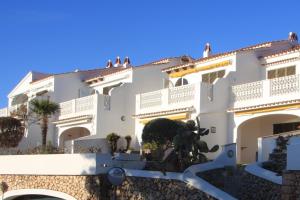 a large white building with trees in front of it at Apartament Bouganville in Alaior