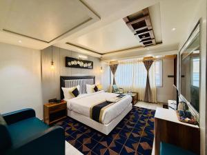 a hotel room with a bed and a couch at Hotel Kama, Patna in Patna