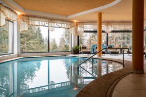 a swimming pool in a house with windows at Sabina Dolomites Puflatsch in Alpe di Siusi