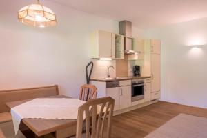 a small kitchen with a table and a dining room at Sabina Dolomites Puflatsch in Alpe di Siusi