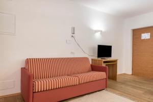 a living room with a couch and a television at Sabina Dolomites Puflatsch in Alpe di Siusi