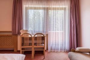 a bedroom with a crib and a large window at Sabina Dolomites Puflatsch in Alpe di Siusi +18 photos