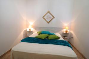 a white bed with green pillows in a room at Bungalow Fragola in Otranto