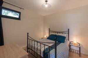a bedroom with a black bed with blue pillows at Gîte les Monteils in Vesseaux +9 photos