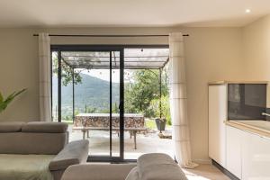 a living room with a couch and a glass door at Gîte les Monteils in Vesseaux