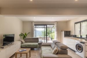 a living room with a couch and a tv at Gîte les Monteils in Vesseaux
