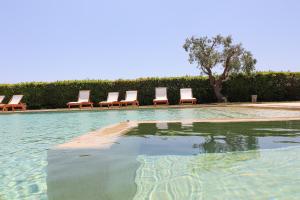 a group of chairs sitting in a swimming pool at Bungalow Fragola in Otranto