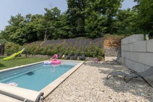a swimming pool with a pink flamingo in a yard at Gîte les Monteils in Vesseaux