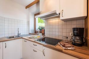 a kitchen with white cabinets and a counter top at Kristiania Apartement Typ A1 in Siusi