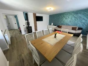 a dining room with a table and chairs and a couch at Cabana Patric Valea Avrigului in Avrig