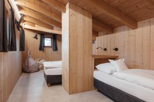 a bedroom with a bed in a wooden room at Ciasa Willy App Conturines in La Villa