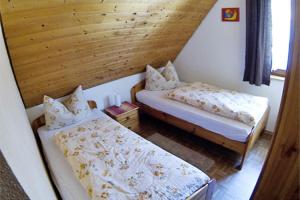 a room with two beds and a wooden wall at Schlossberghof Schnellingen in Haslach im Kinzigtal